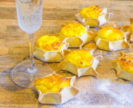 glass of iced sparkling wine with star-shaped sweets with shortcrust pastry, ricotta and creamの写真素材