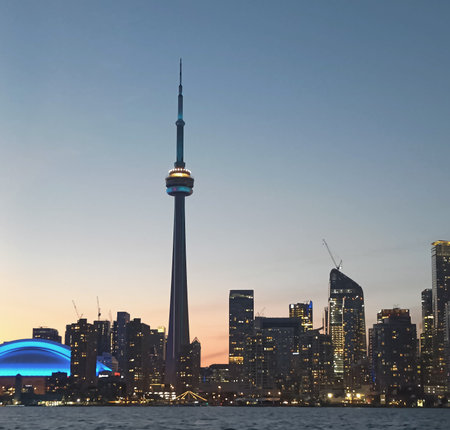 A wide-angle cityscape of the Toronto skyline captured from the waters of Lake Ontario. The image highlights modern skyscrapers, including the CN Tower, with reflections on the watの写真素材