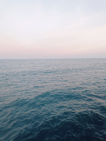 A wide, expansive blue-colored lake with no visible background â minimalistic in composition and resembling the sea. The lakeâs opaque blue surface reflects natural light, creatingの写真素材