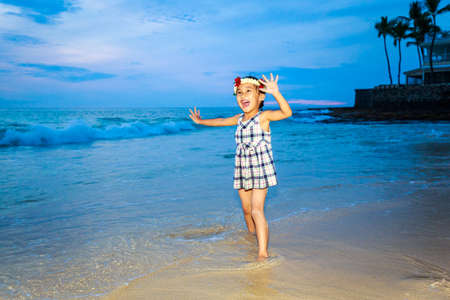 Adorable girl enjoys play time on the beach.の写真素材