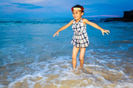 Adorable girl enjoys play time on the beach.の写真素材