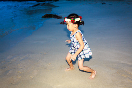 Adorable girl enjoys play time on the beach.の写真素材