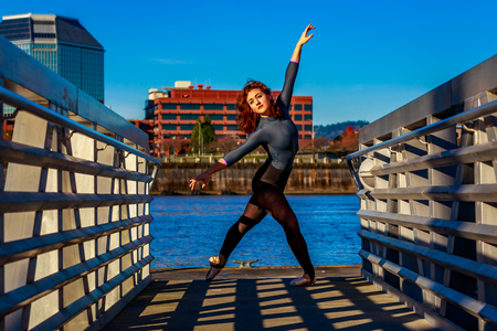 Young female ballet dancer practices at waterfront, Portland downtown.の写真素材