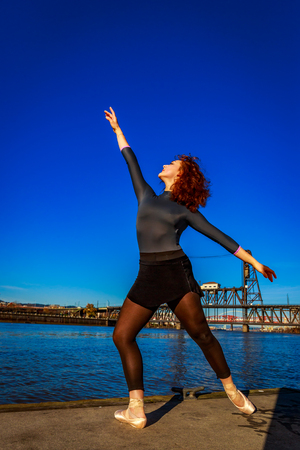 Young female ballet dancer practices at waterfront, Portland downtown.の写真素材