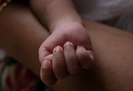 newborn baby fist showing finger nails in indian skin toneの写真素材