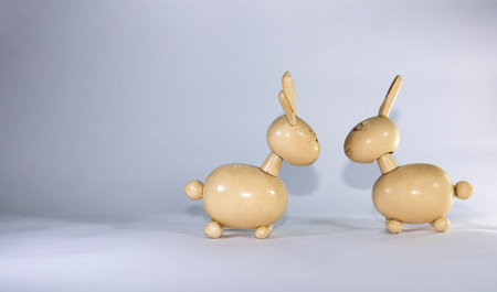 two wooden toy rabbits looking face to faceの写真素材