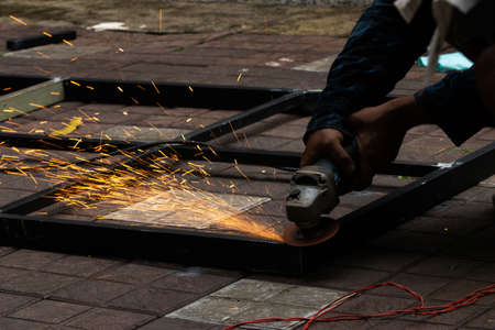 Grinding work on metal frame by a blacksmithの写真素材