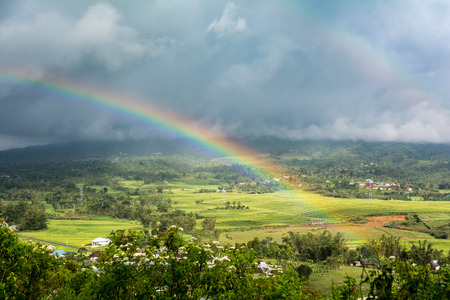 Double Rainbow Over Countryside with a Storm background. Ruteng, Manggarai Regency, Flores, East Nusa Tenggara, Indonesiaの写真素材