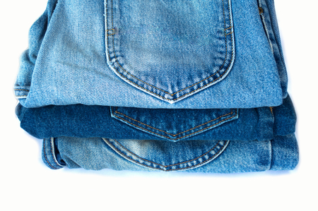 stack of blue jeans on white backgroundの写真素材