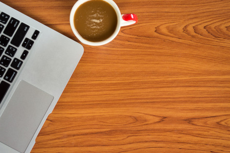 Office table with notepad, laptop and coffee cup.View from above with copy space.の写真素材