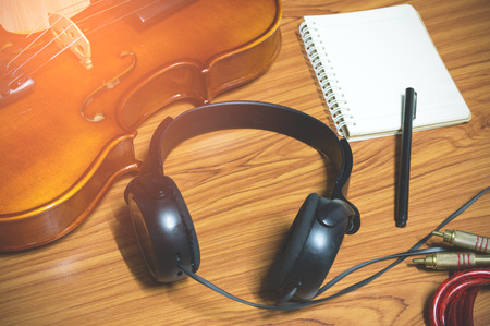 Violin phone notebook on wood background.Top view in music hipster tone.の写真素材