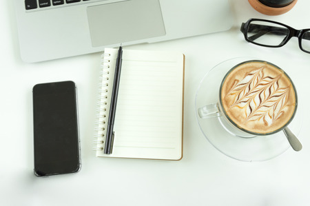 Office table with notepad, laptop and coffee cup.View from above with copy space.の写真素材