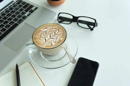 Office table with notepad, laptop and coffee cup.View from above with copy space.の写真素材