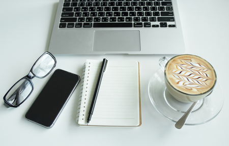 Office table with notepad, laptop and coffee cup.View from above with copy space.の写真素材