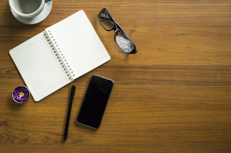 Office table with notepad, laptop and coffee cup.View from above with copy space.の写真素材