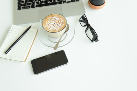 Office table with notepad, laptop and coffee cup.View from above with copy space.の写真素材
