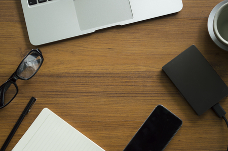Office table with notepad, laptop and coffee cup.View from above with copy space.の写真素材