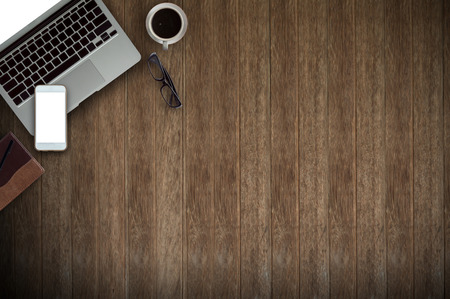 Office desk work with laptop,phone,notepad  and cup of coffee. View from above with copy space.の写真素材