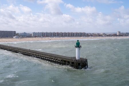 Breakwater of the French port of Calais with the beach and the city.の写真素材