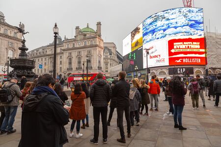LONDON, UK - December 31, 2019: Some people listen to a busker in Piccadilly Circusのeditorial素材