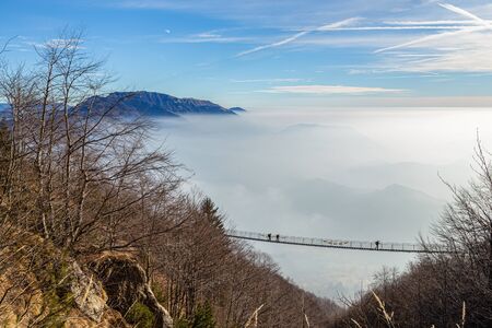 Hikers while crossing a Tibetan bridge located along a path on the - Small Dolomites - in Italyの写真素材