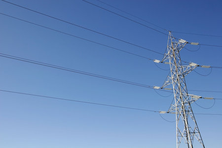 electric power line tower in clear blue sky