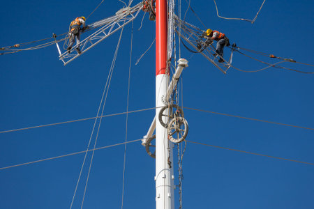 Workers repairing a high voltage industrial power energy line. Great for energy, safety and...