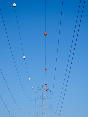 High tension electrical power lines and pylon tower against sky. Modern industrial energy line.の写真素材