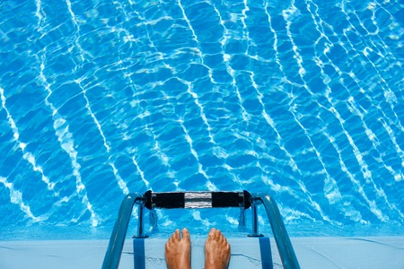 Hotel swimming pool with blue and sunny reflections, in a hot summer vacations.の写真素材