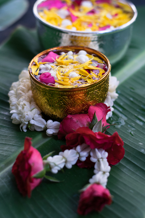 Thai traditional jasmine garland and Colorful flower in water bowls decorating and scented water, perfume on Banana leaf for Songkran Festival or Thai New Year.の写真素材
