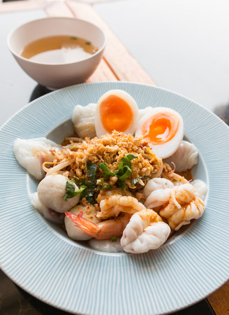 Traditional Thai food - steamed rice-skin dumplings with egg, vegetable, squid and shrimp served with hot soupの写真素材