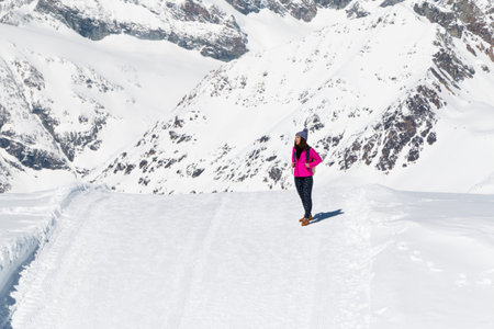 an asian young woman traveling on the snow mountain with happiness in a sunny day, Switzerland