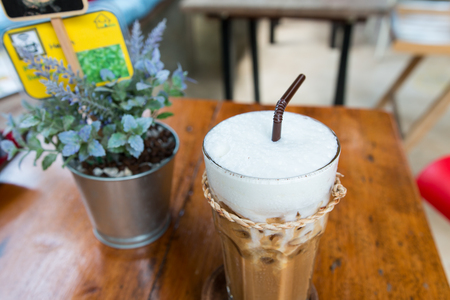 a glass of iced coffee with milk on the wood tableの写真素材