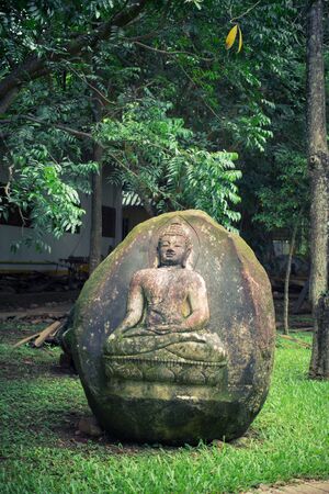 Buddha imprint with sitting pose on stone at temple in nature of thailandの写真素材