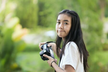 girl try to take natural  photos in parkの写真素材