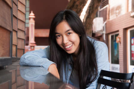 girl smiling on wooden window background in the cityの写真素材