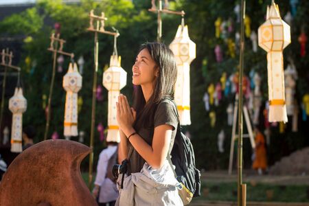 Asian traveler in wai pose during travel of thailand.の写真素材