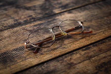 Old's glasses on old wooden tableの写真素材