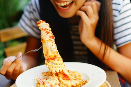 girl eating tasty Cheesy Waffle Fried,  including potato , cheese, mayonnaise and tomato source.の写真素材
