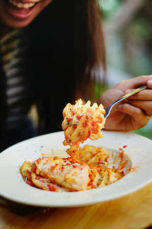 girl eating tasty Cheesy Waffle Fried,  including potato , cheese, mayonnaise and tomato source.の写真素材