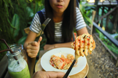 girl eating tasty Cheesy Waffle Fried,  including potato , cheese, mayonnaise and tomato source.の写真素材