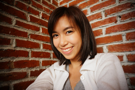 girl in short hair style on red brick backgroundの写真素材