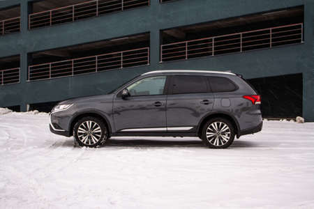 MOSCOW, RUSSIA - JANUARY 30, 2021 Mitsubishi Outlander. Third generation of Japanese compact crossover SUV produced by Mitsubishi Motors. Model year 2020. Dark Mitsubishi on winter background. Front side close up view.のeditorial素材