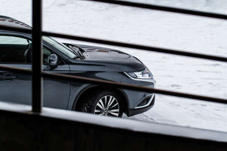 MOSCOW, RUSSIA - JANUARY 30, 2021 Mitsubishi Outlander. Third generation of Japanese compact crossover SUV produced by Mitsubishi Motors. Model year 2020. Dark Mitsubishi on winter background. Front side close up view.のeditorial素材