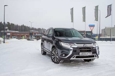 MOSCOW, RUSSIA - JANUARY 30, 2021 Mitsubishi Outlander. Third generation of Japanese compact crossover SUV produced by Mitsubishi Motors. Model year 2020. Dark Mitsubishi on winter background. Front side close up view.のeditorial素材
