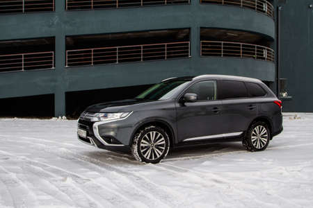 MOSCOW, RUSSIA - JANUARY 30, 2021 Mitsubishi Outlander. Third generation of Japanese compact crossover SUV produced by Mitsubishi Motors. Model year 2020. Dark Mitsubishi on winter background. Front side close up view.のeditorial素材