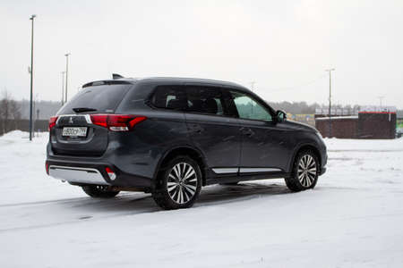 MOSCOW, RUSSIA - JANUARY 30, 2021 Mitsubishi Outlander. Third generation of Japanese compact crossover SUV produced by Mitsubishi Motors. Model year 2020. Dark Mitsubishi on winter background. Rear side close up view.のeditorial素材