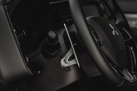 MOSCOW, RUSSIA - JANUARY 30, 2021 Mitsubishi Outlander dark interior view. Third generation of Japanese compact crossover SUV. Mitsubishi Motors company badge close up view on the steering wheel.のeditorial素材