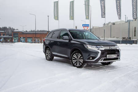 MOSCOW, RUSSIA - JANUARY 30, 2021 Mitsubishi Outlander. Third generation of Japanese compact crossover SUV produced by Mitsubishi Motors. Model year 2020. Dark Mitsubishi on winter background. Front side close up view.のeditorial素材