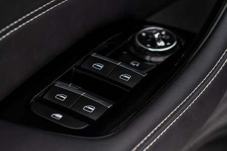 Close up view of button controlling window in modern car interior. Vehicle interior detail. Door handle with windows controlsの写真素材